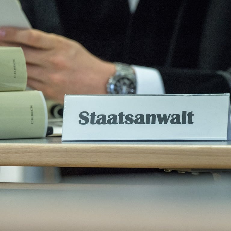 Ein Schild mit der Aufschrift «Staatsanwalt» neben zwei Strafgesetzbüchern (Foto: picture-alliance / Reportdienste, Armin Weigel)