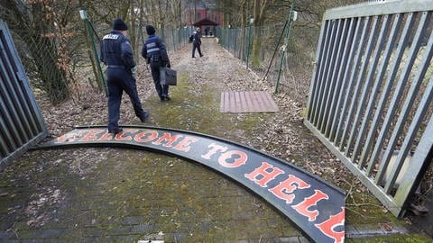 Die Polizei läuft über ein am Boden liegendes Schild mit Aufschrift "Welcome to Hell". Es gehörte zum Vereinsheim der Hells Angels Bonn. (Foto: picture alliance / dpa | Thomas Frey)