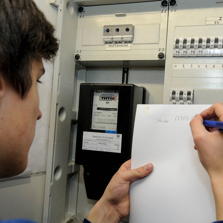 Ein Mann liest einen Stromzähler ab. Die Energieversorgung Mittelrhein warnt vor Betrüger, die sich als Mitarbeiter des Unternehmens ausgeben, um Daten der Kunden zu stehlen.
