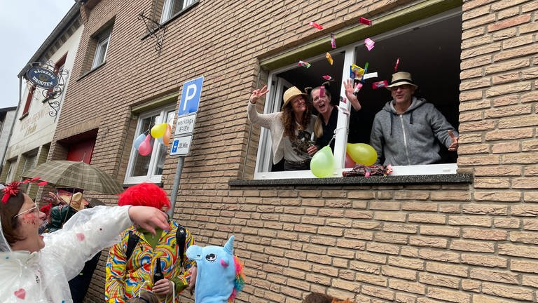 Karnevalisten in Grafschaft-Bölingen fangen die Kamelle direkt aus dem Wohnzimmerfenster.
