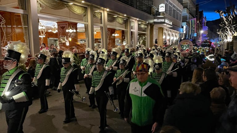 Eine Musikkapelle in schwarz-weiß-grünen Uniformen marschiert beim Abendumzug 2024 in Boppard mit. 