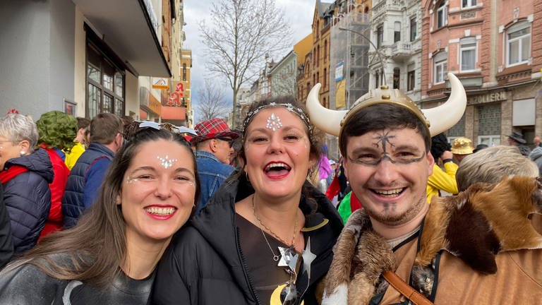 Drei fröhliche Karnevalisten beim Rosenmontagsumzug 2024 in Koblenz