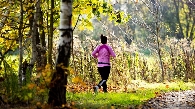 Eine Frau joggt durch einen Wald (Foto: IMAGO, IMAGO/Emmanuele Contini)