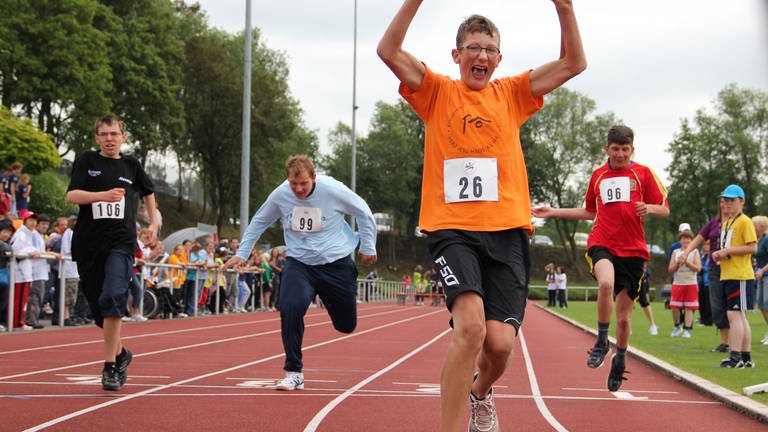Vier Jungen rennen auf einem Sportplatz ins Ziel (Foto: Special Olympics Rheinland-Pfalz)