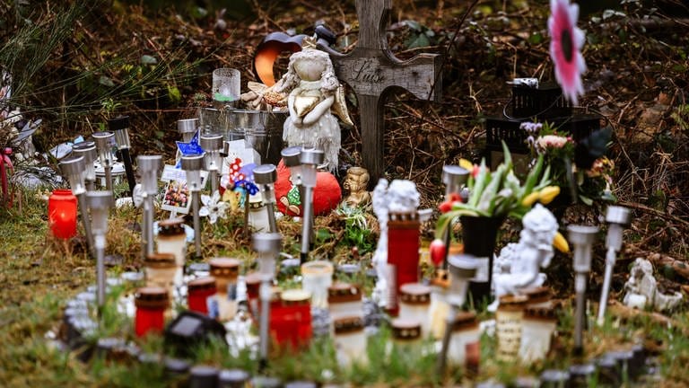 Kerzen, Blumen und Figuren liegen am Fundort der Leiche von Luise an der Landesgrenze zwischen Rheinland-Pfalz und Nordrhein-Westfalen. (Foto: dpa Bildfunk, Picture Alliance)
