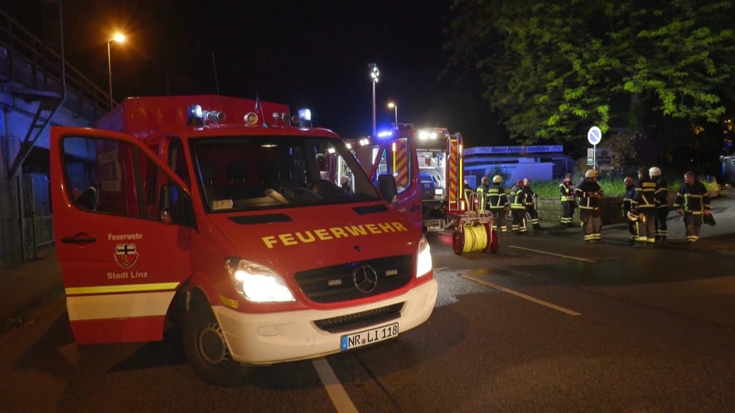 Feuerwehrleute vor einem Hotel in Linz, in dem es in der Nacht gebrannt hat. (Foto: SWR)