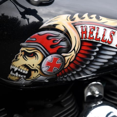 Das Hells Angels-Emblem, ein Totenkopf mit Helm und Flügeln, ist auf dem Tank eines abgestellten Motorrads zu sehen (Foto: dpa Bildfunk, picture alliance/dpa | Arne Dedert)
