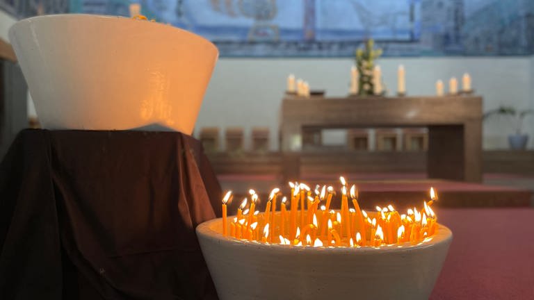 Kerzen brennen in der Christ König Kirche, die bei der Gedenkandacht für die Opfer der Messerattacke in Oggersheim angezündet wurden. (Foto: SWR)