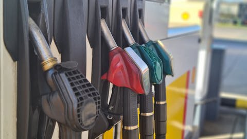 Benzin und Diesel zum Tanken an einer Zapfsäule: Zu sehen sind Zapfpistolen an einer Tankstelle. Sie unterscheiden sich farblich, wie auch die Preise.