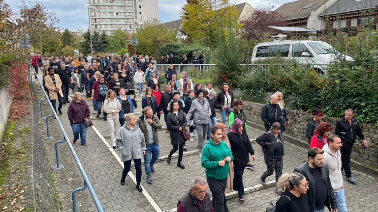 Menschen gedenken in Ludwigshafen-Oggersheim an die Opfer der Messerattacke. (Foto: SWR)