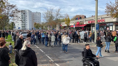 Viele Menschen versammelten sich am Sonntag vor dem Drogeriemarkt in Ludwigshafen, in dem der mutmaßliche Täter ein drittes Opfer mit einem Messer attackierte. (Foto: SWR)