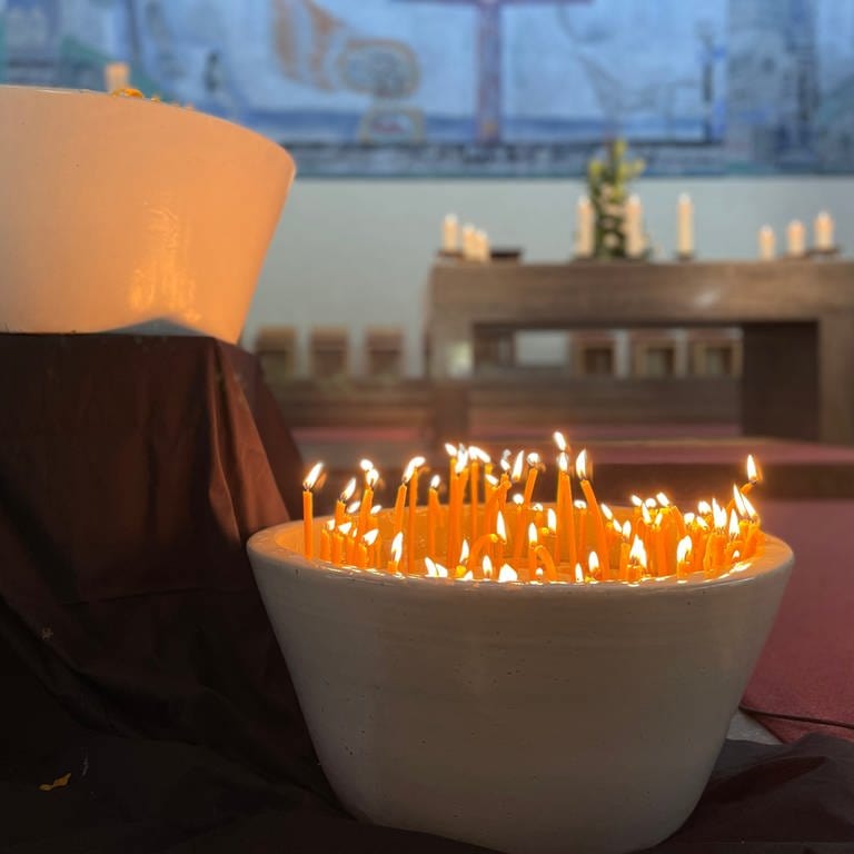 Kerzen brennen in der Christ König Kirche, die bei der Gedenkandacht für die Opfer der Messerattacke in Oggersheim angezündet wurden. (Foto: SWR)