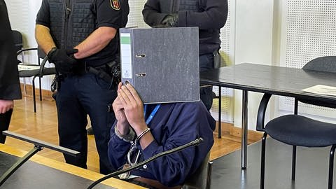 Der Angeklagte verbirgt sein Gesicht vor den Pressevertretern (Foto: SWR)