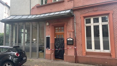 Tatort Gaststätte im Hemshof von Ludwigshafen in dem der Wirt niedergestochen wurde, außenansicht, Tür verbrettert mit rotem Polizeiabsperrband davor