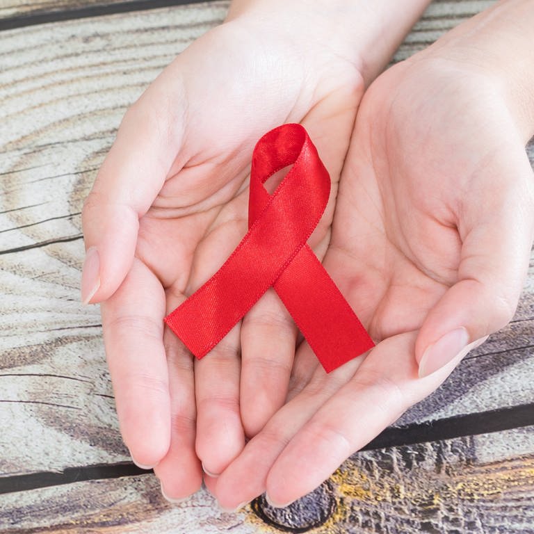 Rote Schleife, Symbol der Solidarität mit HIV-infezierten und aidskranken Menschen, Symbolbild zum Welt-Aids-Tag (Foto: IMAGO, Wirestock)