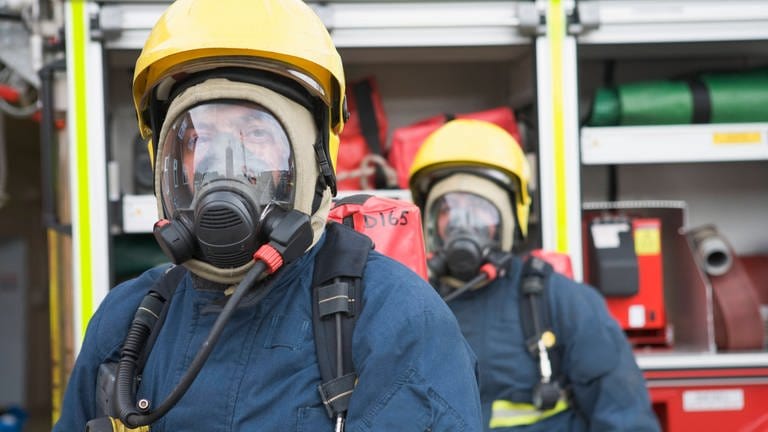 Zwei Feuerwehrmänner mit Atemschutzgerätz - Symbolbild für Mehrfamilienhaus in Landau nach Kohlenmonoxidalarm geräumt