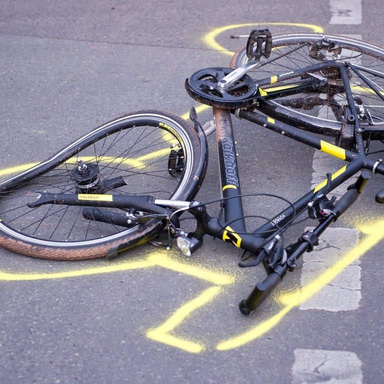 Ein zerstörtes Fahrrad liegt auf der Straße. Symboldbild für Artikel: Mann wirft Fahrrad auf Politiker in Speyer. (Bildquelle: dpa-Bildfunk, Daniel Naupold) 