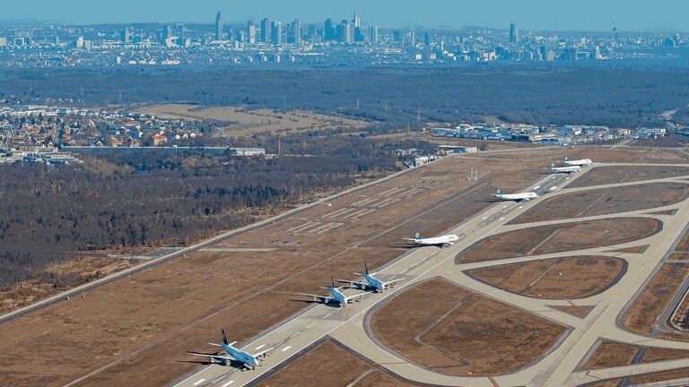 Flugzeuge der Fluggesellschaft Lufthansa, darunter solche des Typs Boeing 747, stehen geparkt auf dem Flughafen auf der Landebahn Nordwest mit der Skyline der Innenstadt im Hintergrund. (Foto: dpa Bildfunk,  Vasco Garcia)