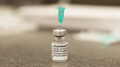 Eine Nadel steck in einer Ampulle mit dem Corona-Impfstoff Comirnaty von BioNTechPfizer.  (Foto: dpa Bildfunk, Picture Alliance)