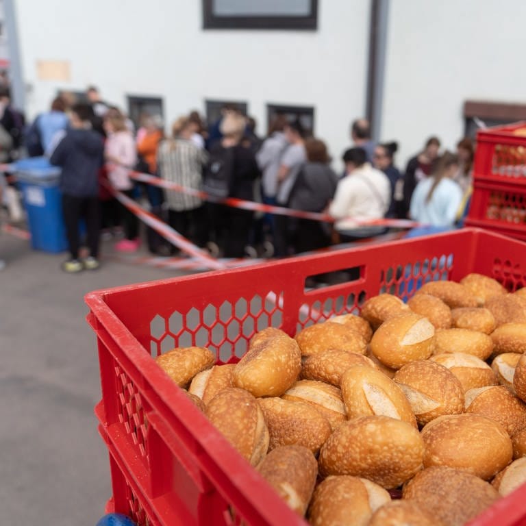 Backwaren werden für einen Tafel-Laden angeliefert, während überwiegend ukrainische Geflüchtete für die Essenausgabe anstehen. (Foto: dpa Bildfunk, Nicolas Armer)