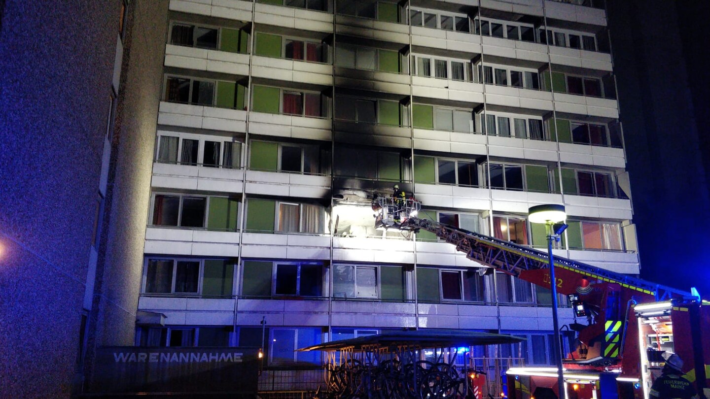 Eine lange Drehleiter der Feuerwehr steht vor dem verrauchten Balkon im zweiten Stock des Mainzer Hochhauses. (Foto: mainz112)