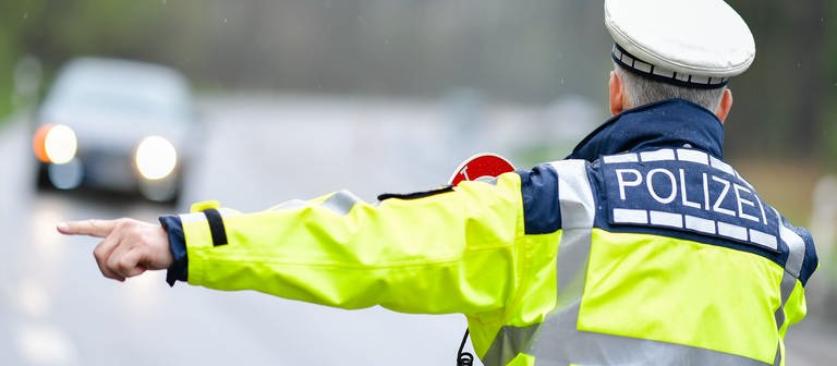 Ein Polizeibeamter kontrolliert einen Autofahrer auf Alkohol am Steuer. (Foto: dpa Bildfunk, picture alliance/dpa | Uwe Anspach)