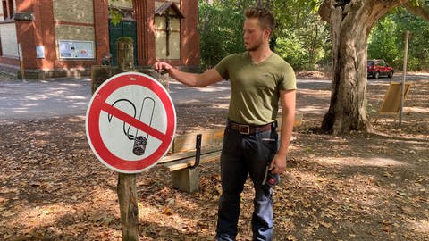 Stadtwaldranger Fabian Emde steht im Lennebergwald neben einem Rauchen-Verboten-Schild (Foto: SWR)