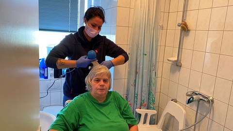 Milena Battle vom Mainzer Pflegedienst föhnt Jeanette Krauß die Haare.  (Foto: SWR, Rabea Amri )