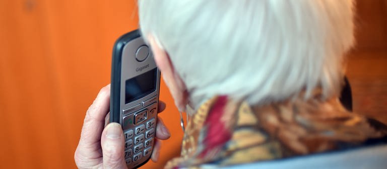 Eine Seniorin hält ein Telefon in der Hand. (Foto: dpa Bildfunk, picture alliance/dpa/dpa-Zentralbild | Britta Pedersen)