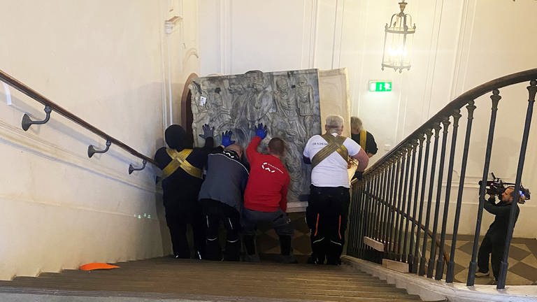 Neun Umzugshelfer hieven einen Sarkophag durchs Treppenhaus im Kurfürstlichen Schloss in Mainz (Foto: Esmen/RGZM)