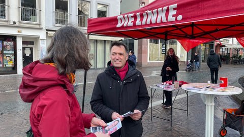 Martin Malcherek vor seinem Wahlkampf-Stand auf dem Mainzer Schillerplatz im Gespräch mit einer Mainzer Bürgerin. (Foto: SWR, Ilona Hartmann)