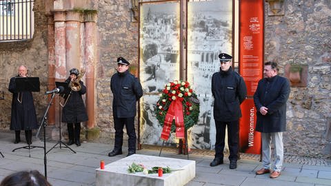 Der Mainzer Bürgermeister Günter Beck steht mit zwei Männern neben einem Kranz zum Gedenken an die Bombardierung von Mainz vor 78 Jahren (Foto: SWR, Daniel Brusch)