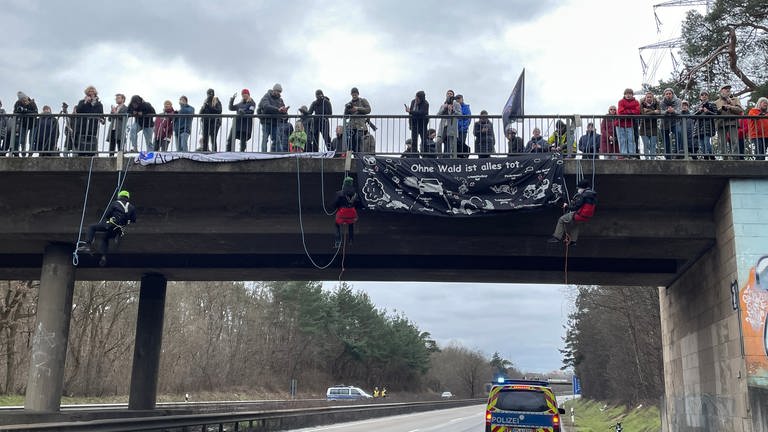 Demonstranten seilen sich von einer Brücke auf die A643 ab (Foto: SWR)