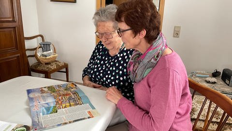 Die Zeitschenkerin Stephanie Albrecht liest Brunhilde Seemann etwas vor. Die Seniorin sieht nicht mehr gut und freut sich über die Abwechslung. (Foto: SWR, Vanessa Siemers)