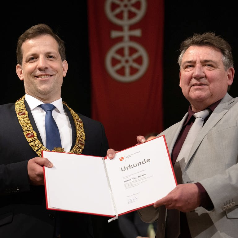 Nino Haase (l.) erhält von Günter Beck die Ernennungsurkunde zum Oberbürgermeister von Mainz (Foto: dpa Bildfunk, picture alliance/dpa | Sebastian Gollnow)