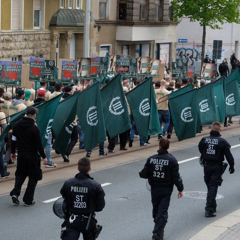Bei einer Demonstration marschieren Mitglieder der Partei der III. Weg. Daneben laufen Polizisten. (Foto: dpa Bildfunk, picture alliance/dpa/dpa-Zentralbild | Sebastian Willnow)