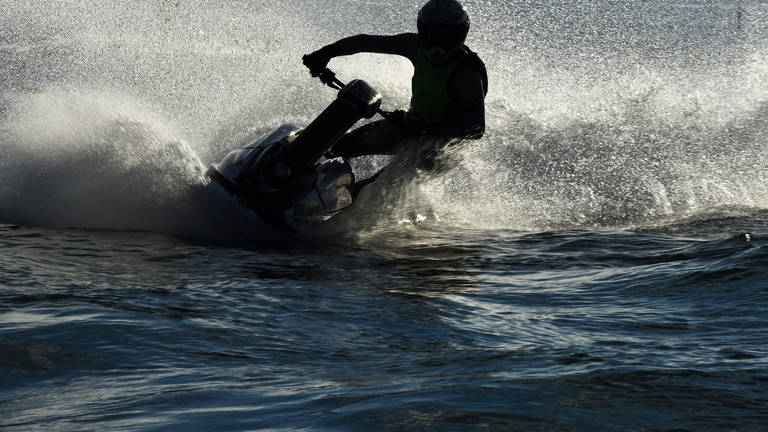Ein Jetski-Fahrer fährt eine Kurve auf dem Wasser. (Foto: dpa Bildfunk, Picture Alliance)