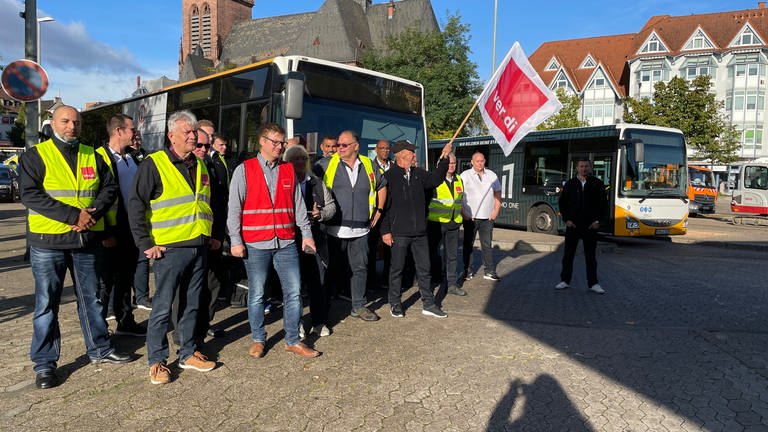 Streikende Busfahrer mit Warnwesten vor einem Bus in Bad Kreuznach (Foto: SWR)