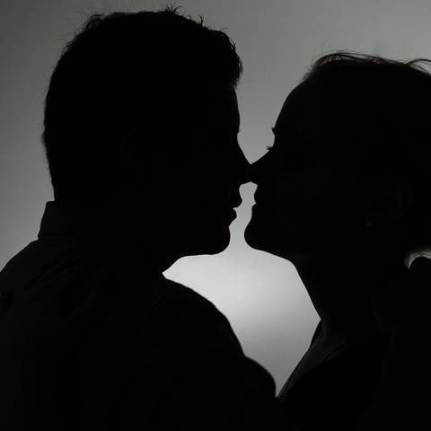 Ein Mann und eine Frau küssen sich. Immer wieder fallen Menschen auf der Suche nach der großen Liebe aber auf Betrüger herein.  (Foto: dpa Bildfunk, picture alliance / dpa | Jan-Philipp Strobel)