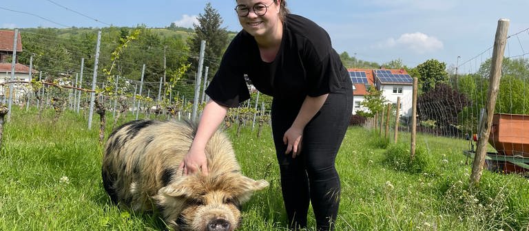 Schwein Emma lässt sich von Winzerin Laurence im Weinberg kraulen. (Foto: SWR, Sibylle Jakobi)