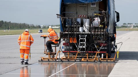 Eine spezielle Flüssig-Grundierung bringen Arbeiter mit einem Spezialfahrzeug auf der Landebahn Nordwest auf dem Flughafen in Frankfurt an. (Foto: dpa Bildfunk, Boris Roessler)