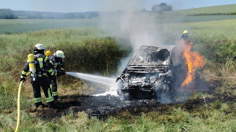 letzte Löscharbeiten an einem völlig ausgebranntes Auto in einem Feld bei Hargesheim (Foto: Feuerwehr VG Rüdesheim)