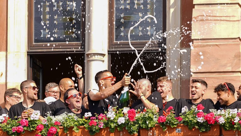 Spieler und Vereinsobere des SVWW feiern auf dem Balkon des Wiesbadener Rathauses den Wiederaufstieg. (Foto: IMAGO, IMAGO / Rene Schulz)