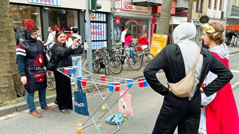 Junge Leute haben zum Rosenmontagszug in Mainz einen Wäscheständer mitgebracht und spielen das Trinkspiel Beer-Pong. (Foto: SWR, A. Dietz)