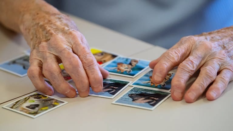 Eine Seniorin spielt  das Spiel "Memory" und legt Kartenpaare zusammen. Alzheimer und andere Demenzerkrankungen gehören nach Angaben der Weltgesundheitsorganisation (WHO) neu zu den zehn häufigsten Todesursachen weltweit. (Foto: dpa Bildfunk, Die lange Suche nach der Therapie - Mainzer Biochemikerin erhält Alzheimer-Preis )