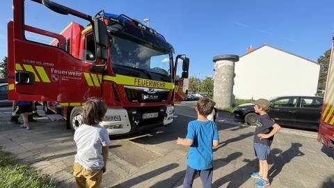 Drei Jungs bewundern das große Einsatzfahrzeug der Feuerwehr (Foto: Stadt Mainz/Feuerwehr)