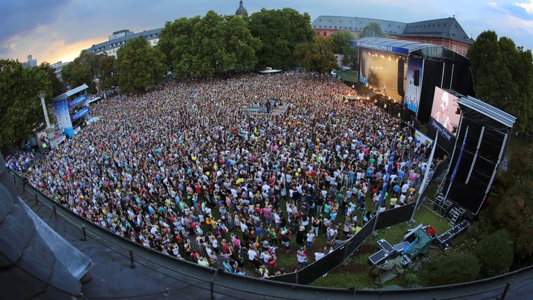 Zuschauerinnen und Zuschauer vor einer Bühne bei einem Open Air in Mainz (Foto: dpa Bildfunk, Picture Alliance)