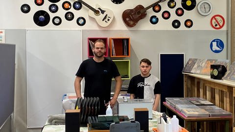 Mitarbeiter und Betreuer stehen in der Vinyl-Ecke zum Schallplatten-Reinigen (Foto: SWR)