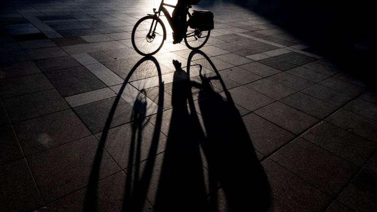 Silhouette eines Fahrradfahrers im Dunkeln von hinten beleuchtet (Foto: dpa Bildfunk, picture alliance/dpa | Federico Gambarini)