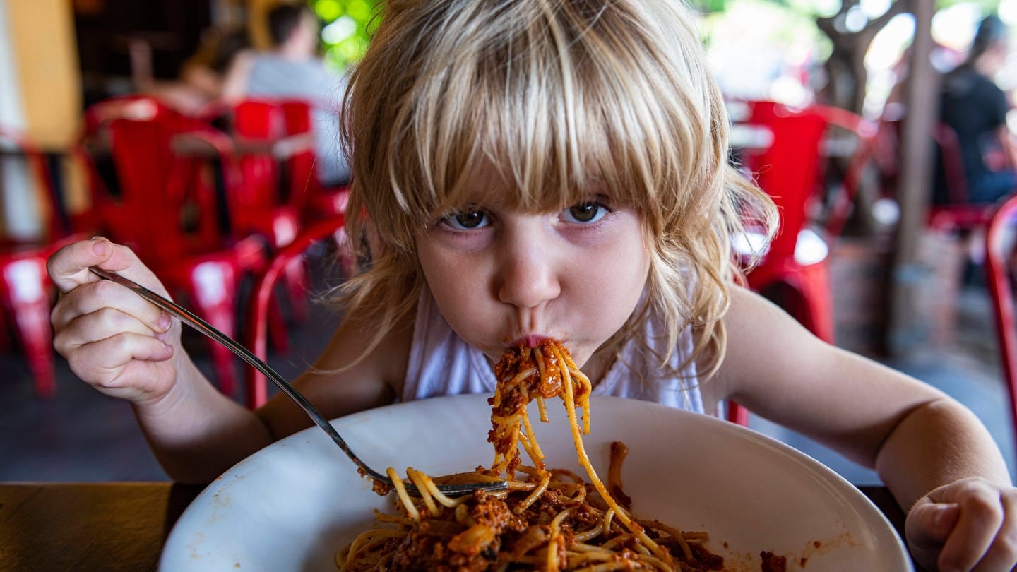 Mädchen isst Spaghetti im Restaurant (Foto: IMAGO, IMAGO / Westend61)